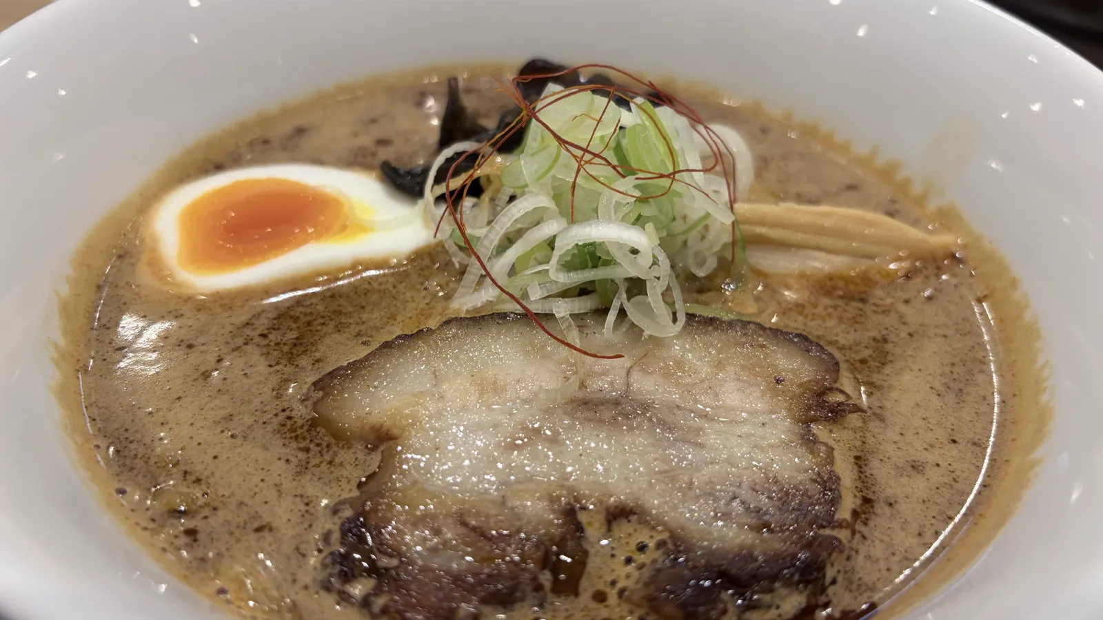 寅乃虎のスパイスらーめんこってり。炙りチャーシューと味玉、キクラゲとメンマがのった味噌ベースの一杯