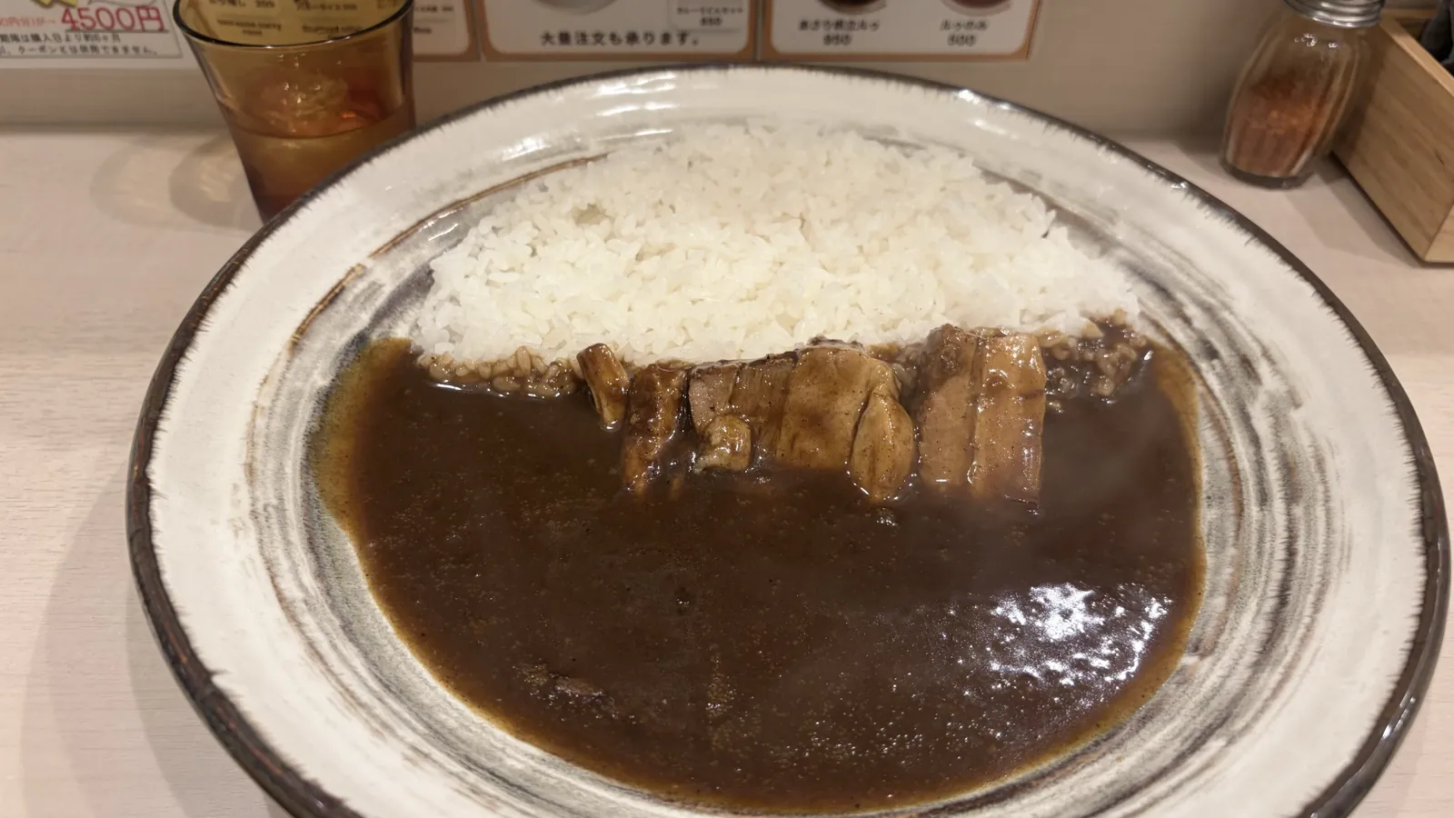 うずの豚角煮カレー950円。黒くサラサラのルウに炙った豚角煮が5切れ並ぶ