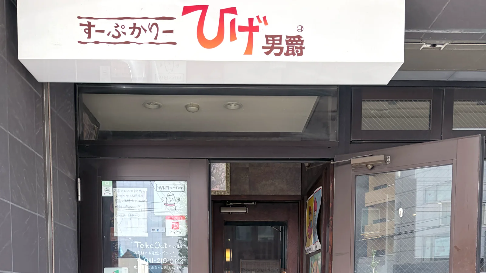 すーぷかりーひげ男爵の外観。白い看板の下にテイクアウトやPayPayの表示がある入口