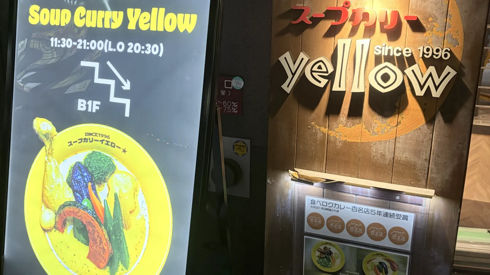 スープカリーイエローの店頭看板。営業時間11時30分から21時と食べログカレー百名店5年連続受賞の掲示