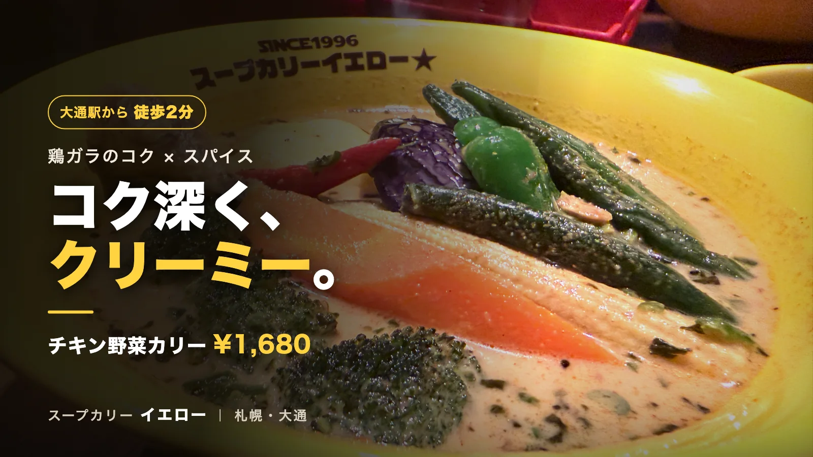 スープカリーイエローのチキン野菜カリー。黄色い器にクリーミーなスープと赤唐辛子やオクラなどの野菜が並ぶ